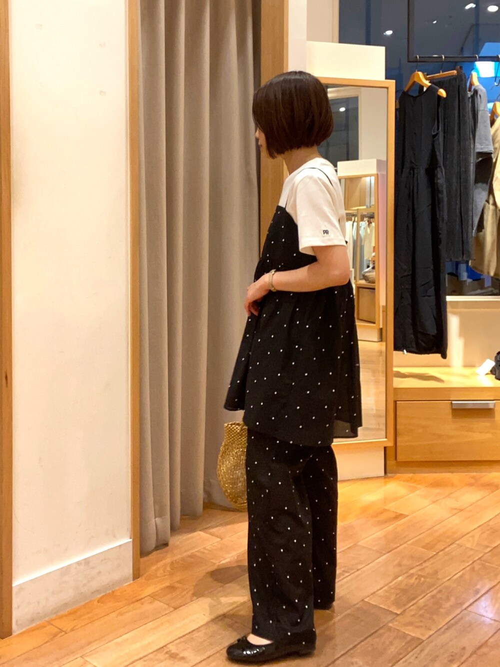 ホワイト系のTシャツ/カットソー、ブラック系のキャミソール、ゴールド系のショルダーバッグを着用したレディースの夏コーディネートの2枚目の写真