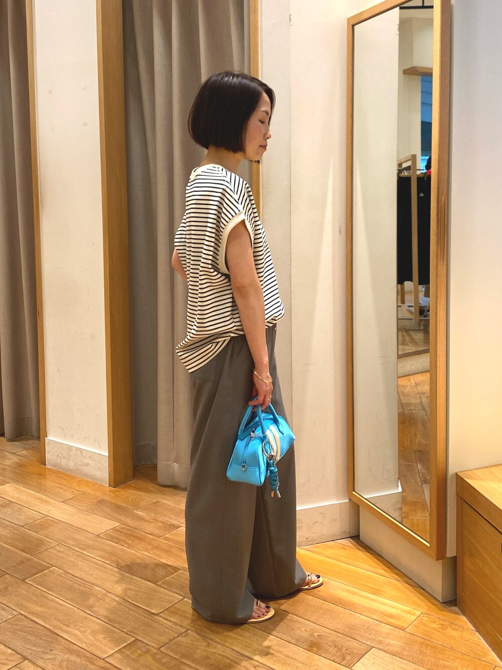 グレー系のその他パンツ、ブルー系のボストンバッグ、ホワイト系のTシャツ/カットソーを着用したレディースの春コーディネートの4枚目の写真