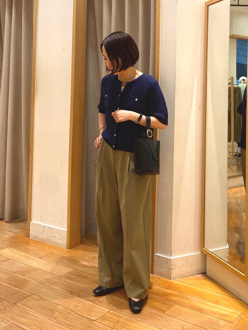 ブルー系のカーディガン/ボレロ、ホワイト系のTシャツ/カットソー、イエロー系のスラックスを着用したレディースの春コーディネートの3枚目の写真