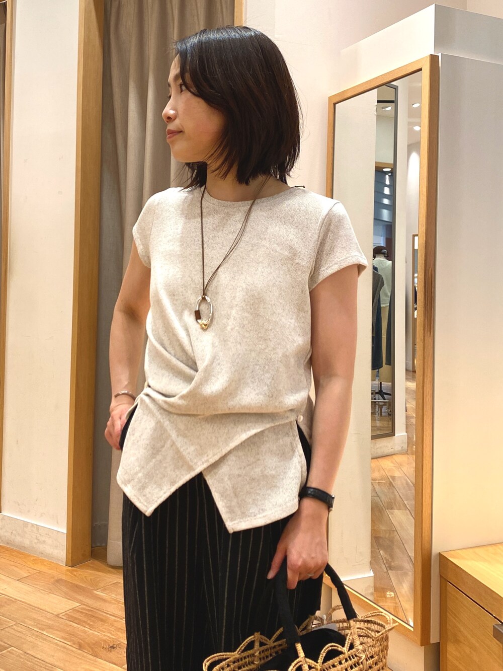 ホワイト系のTシャツ/カットソー、ブラック系のかごバッグ、ブラック系のその他パンツを着用したレディースの夏コーディネートの4枚目の写真