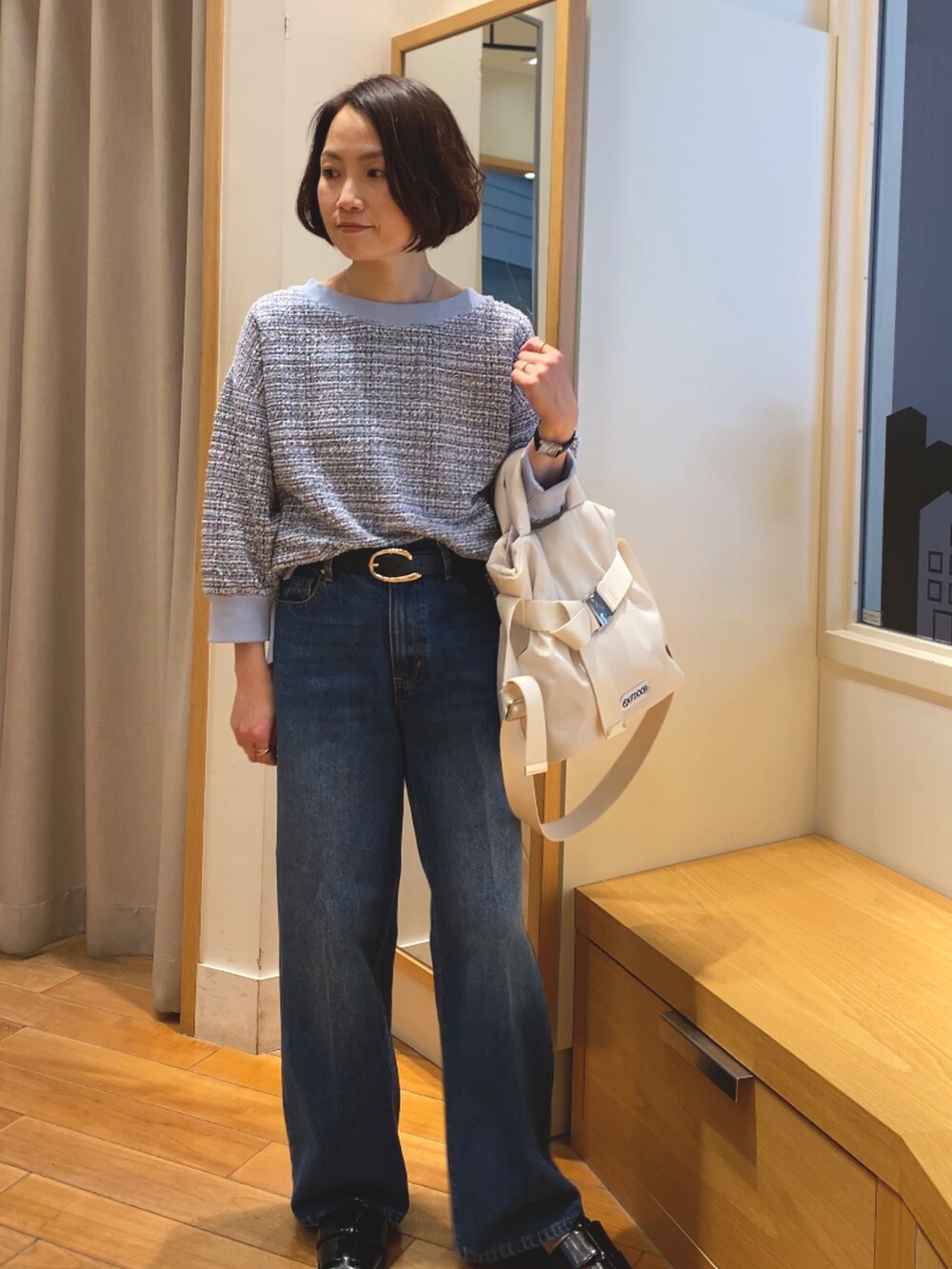 ブルー系のデニムパンツ、ブルー系のTシャツ/カットソー、ホワイト系のショルダーバッグを着用したレディースの春コーディネートの5枚目の写真