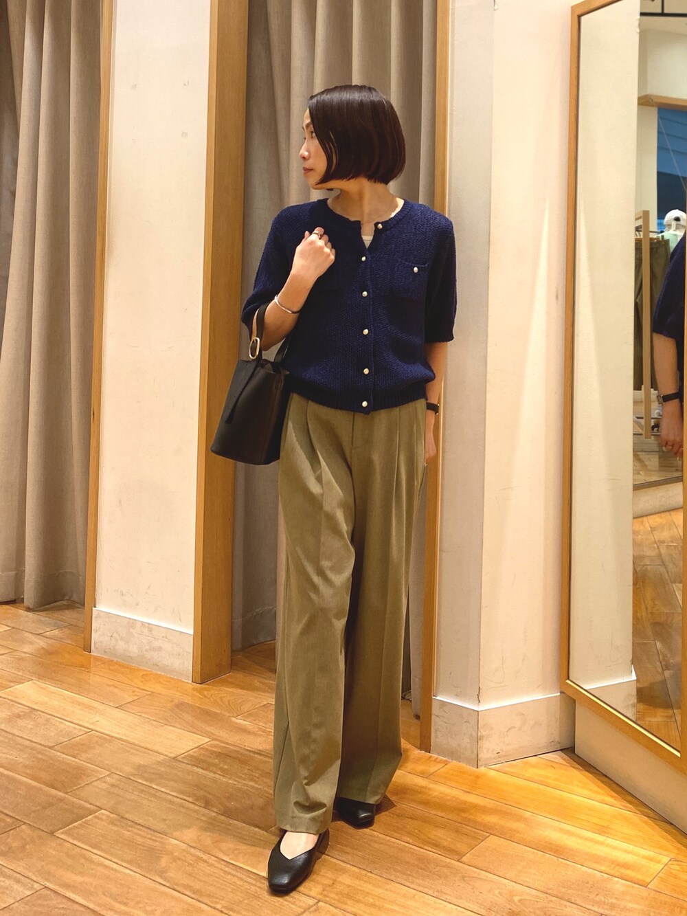 ブルー系のカーディガン/ボレロ、ホワイト系のTシャツ/カットソー、イエロー系のスラックスを着用したレディースの春コーディネートの4枚目の写真