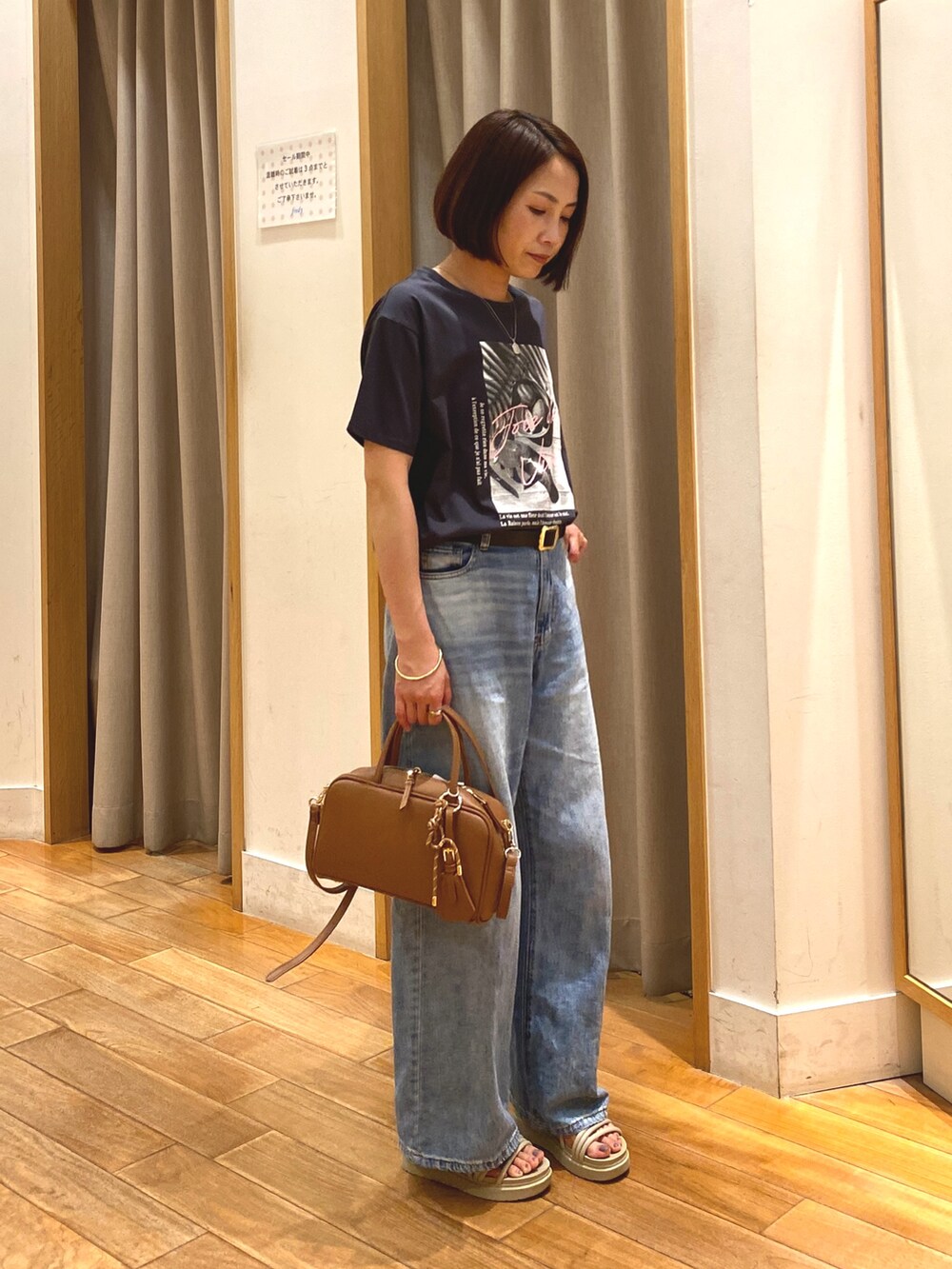 イエロー系のショルダーバッグ、ブルー系のデニムパンツ、グレー系のTシャツ/カットソーを着用したレディースの夏コーディネートの3枚目の写真