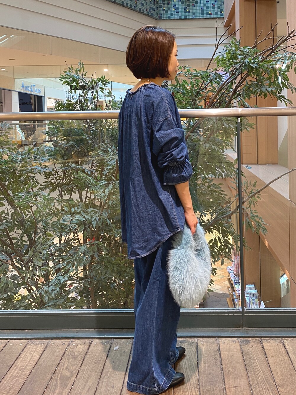 ブルー系のシャツ/ブラウス、ブルー系のデニムパンツ、ホワイト系のTシャツ/カットソーを着用したレディースの秋コーディネートの4枚目の写真