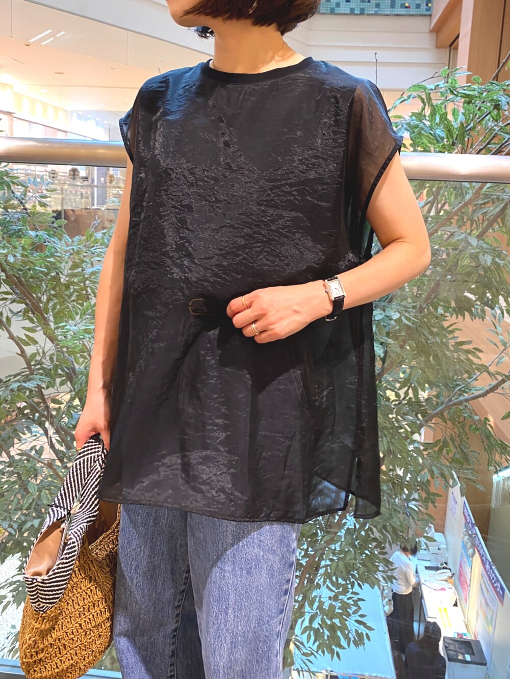 ブラック系のシャツ/ブラウス、ブラウン系のかごバッグ、ブルー系のデニムパンツを着用したレディースの夏コーディネートの3枚目の写真