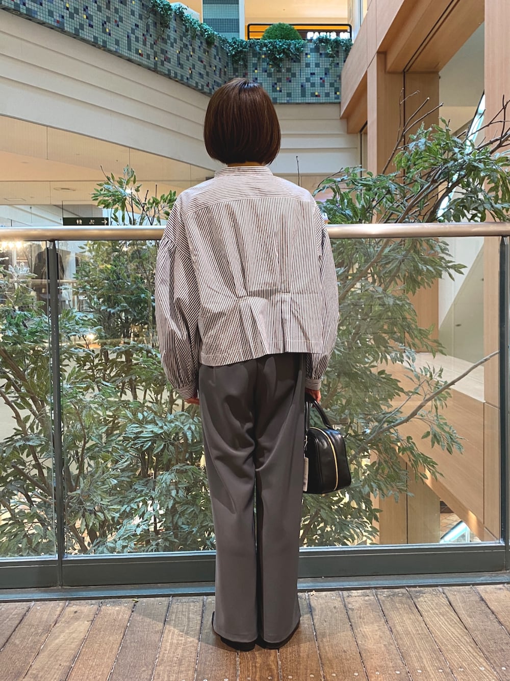 ブルー系のシャツ/ブラウス、ブラック系のハンドバッグ、グレー系のその他パンツを着用したレディースの秋コーディネートの6枚目の写真