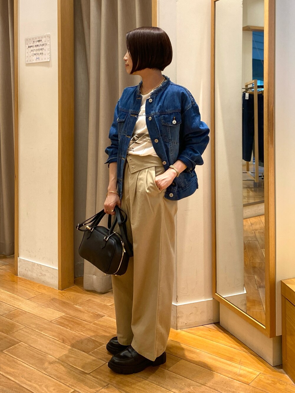 ベージュ系のチノパンツ、ブラック系のショルダーバッグ、ホワイト系のTシャツ/カットソーを着用したレディースの夏コーディネートの4枚目の写真