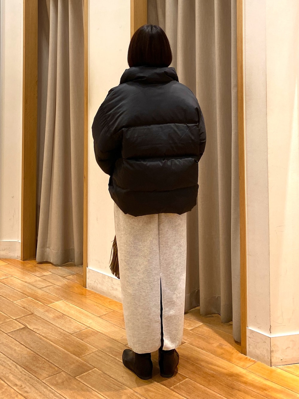 ベージュ系のショルダーバッグ、ブラック系のダウンジャケット/コート、ホワイト系のTシャツ/カットソーを着用したレディースの秋コーディネートの7枚目の写真