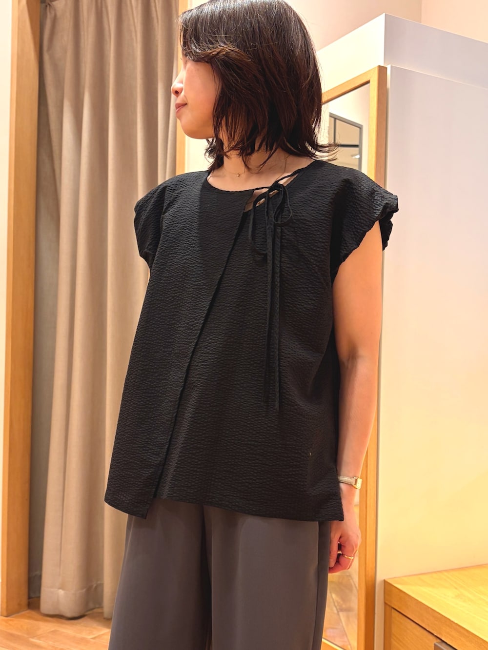 ブラック系のシャツ/ブラウス、グレー系のその他パンツ、シルバー系のかごバッグを着用したレディースの夏コーディネートの3枚目の写真