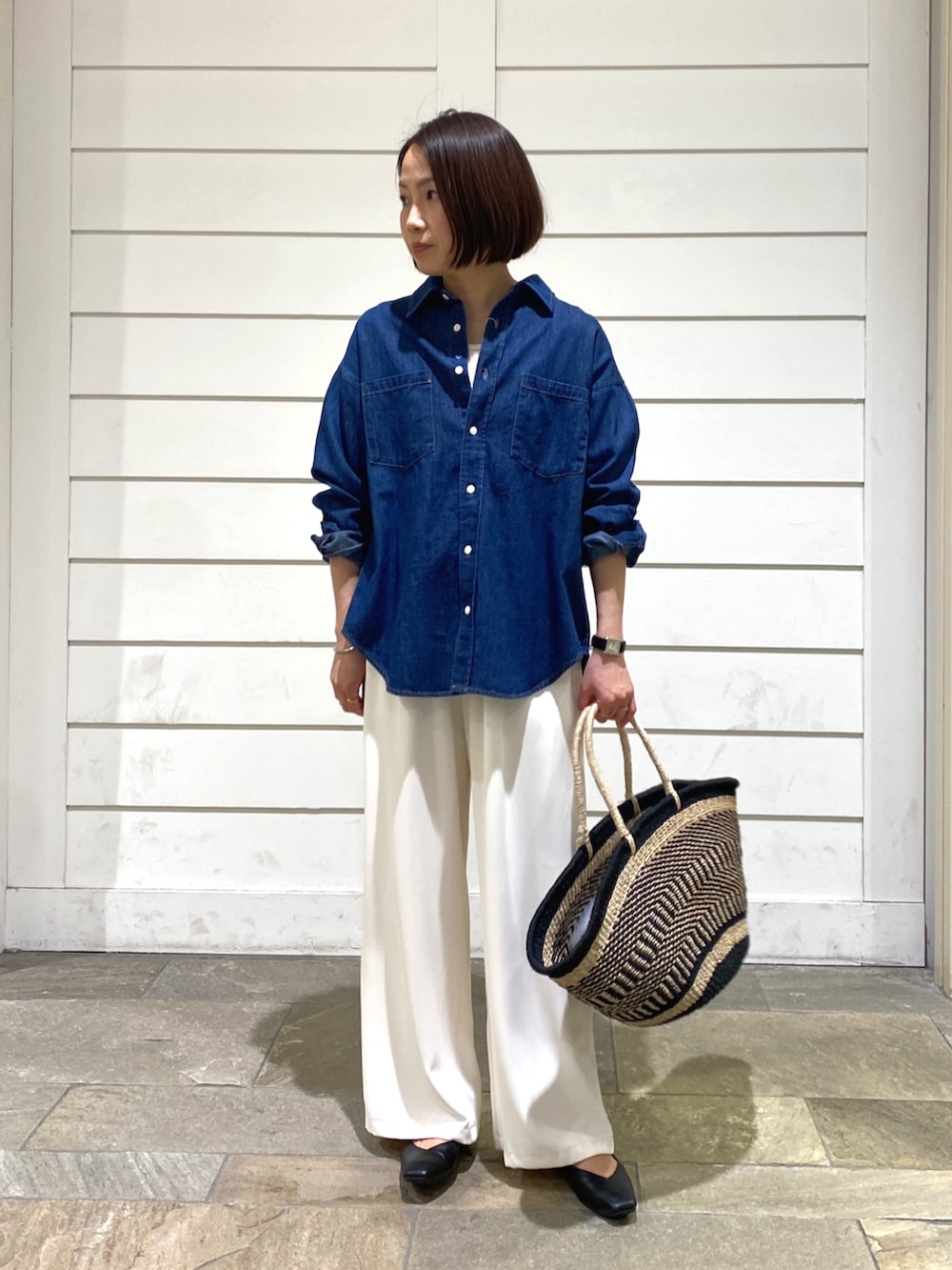 ブルー系のシャツ/ブラウス、ブラック系のかごバッグ、ホワイト系のその他パンツを着用したレディースの春コーディネートの2枚目の写真
