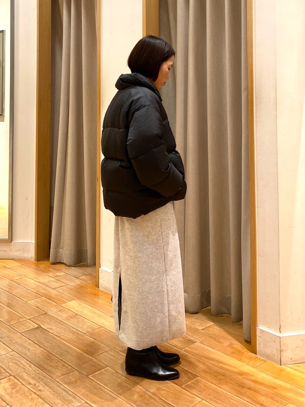 ベージュ系のショルダーバッグ、ブラック系のダウンジャケット/コート、ホワイト系のTシャツ/カットソーを着用したレディースの秋コーディネートの6枚目の写真