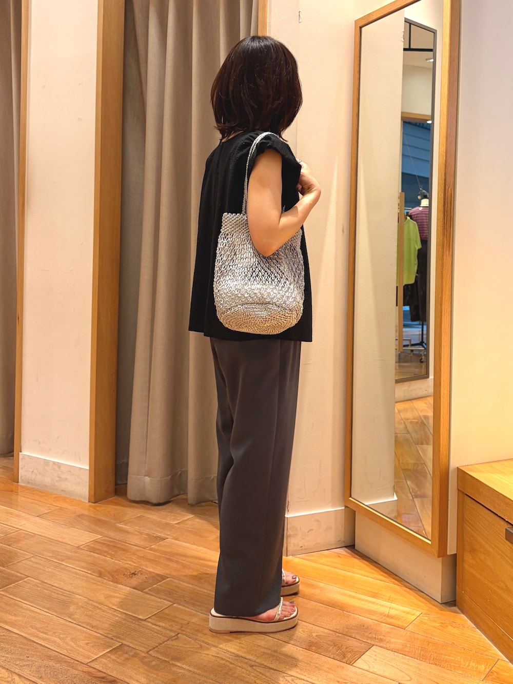 ブラック系のシャツ/ブラウス、グレー系のその他パンツ、シルバー系のかごバッグを着用したレディースの夏コーディネートの6枚目の写真