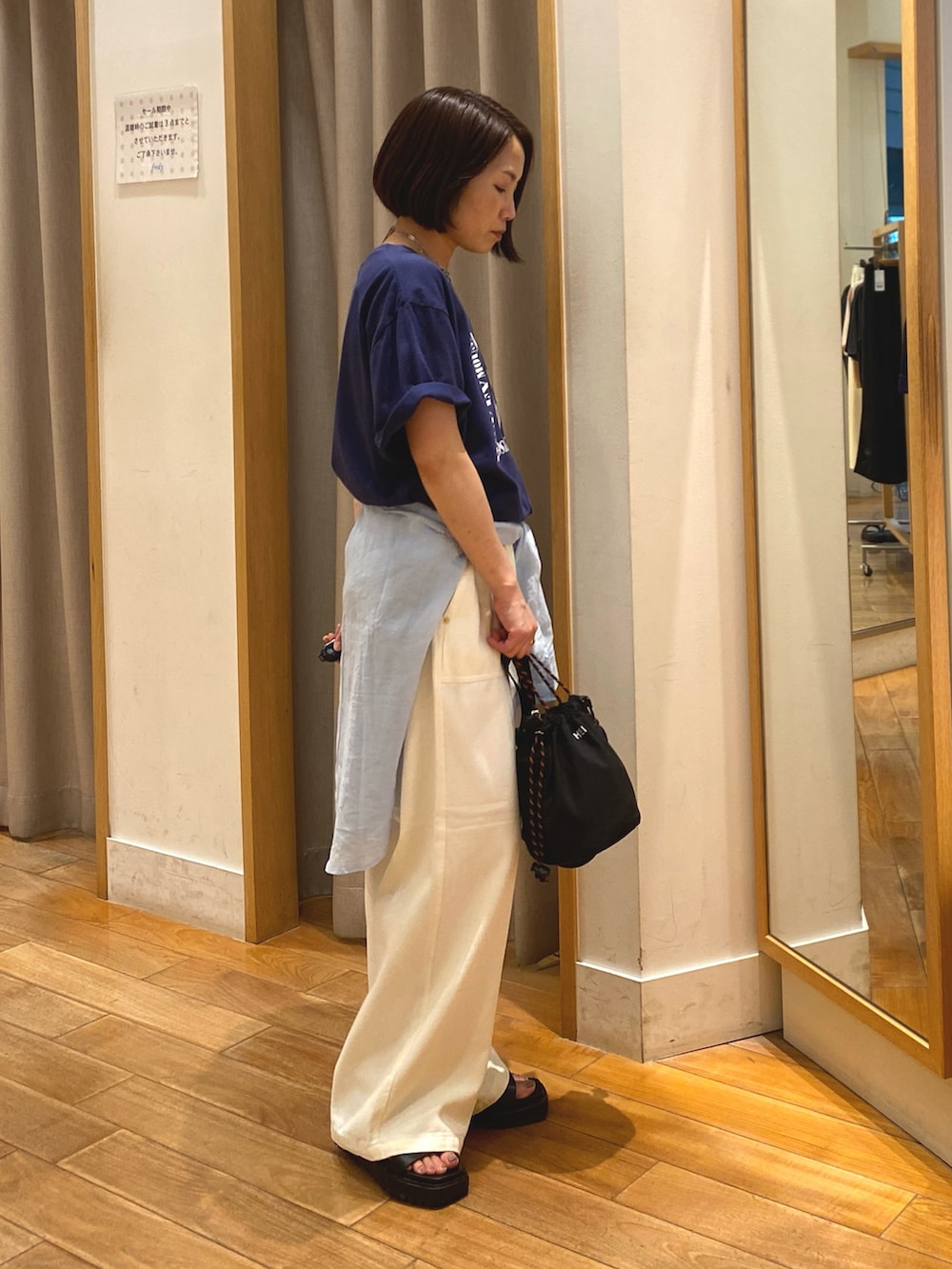 ブルー系のTシャツ/カットソー、ホワイト系のデニムパンツ、ブラック系のショルダーバッグを着用したレディースの夏コーディネートの4枚目の写真