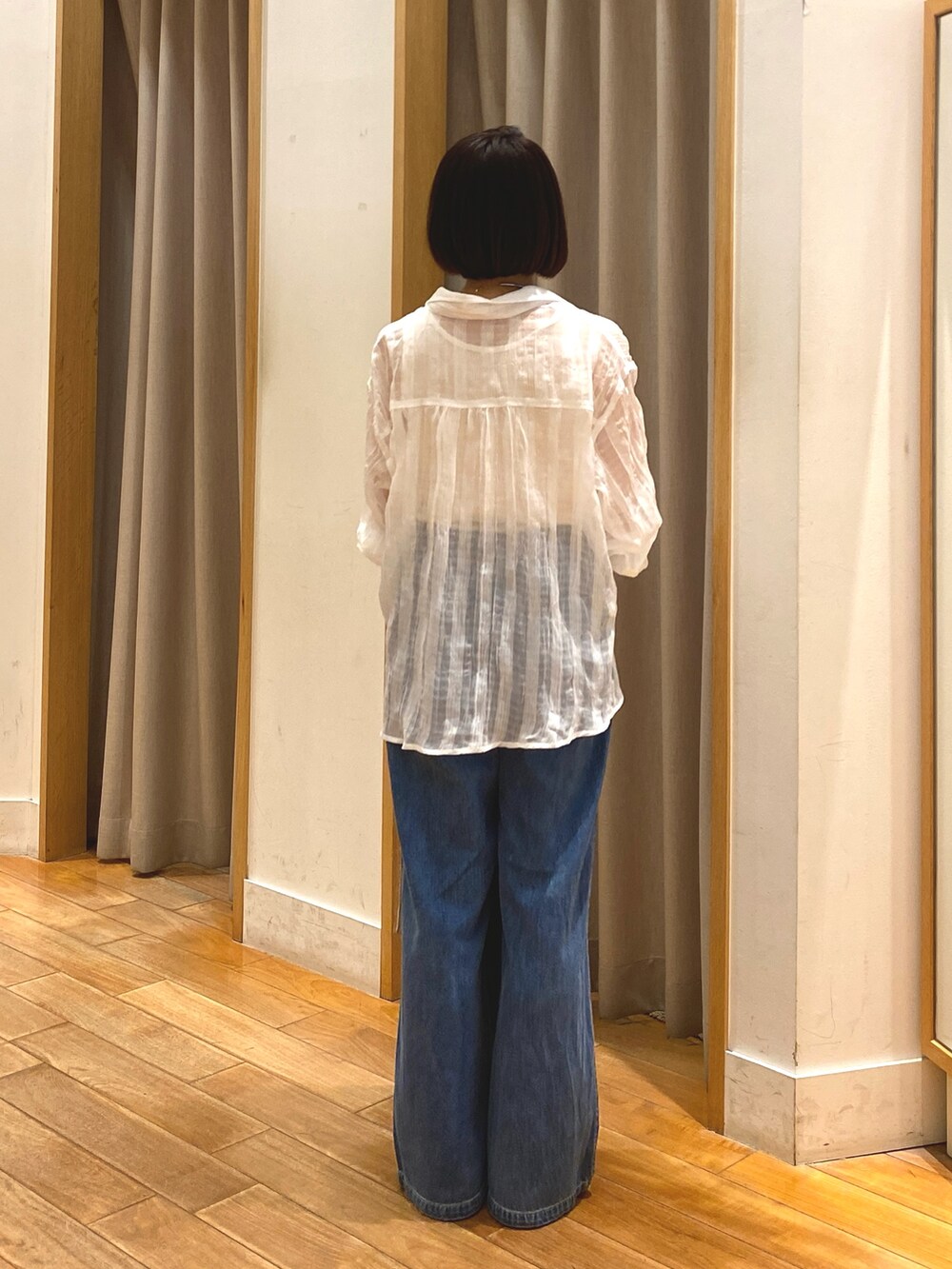 ブルー系のデニムパンツ、ベージュ系のトートバッグ、ホワイト系のシャツ/ブラウスを着用したレディースの春コーディネートの7枚目の写真