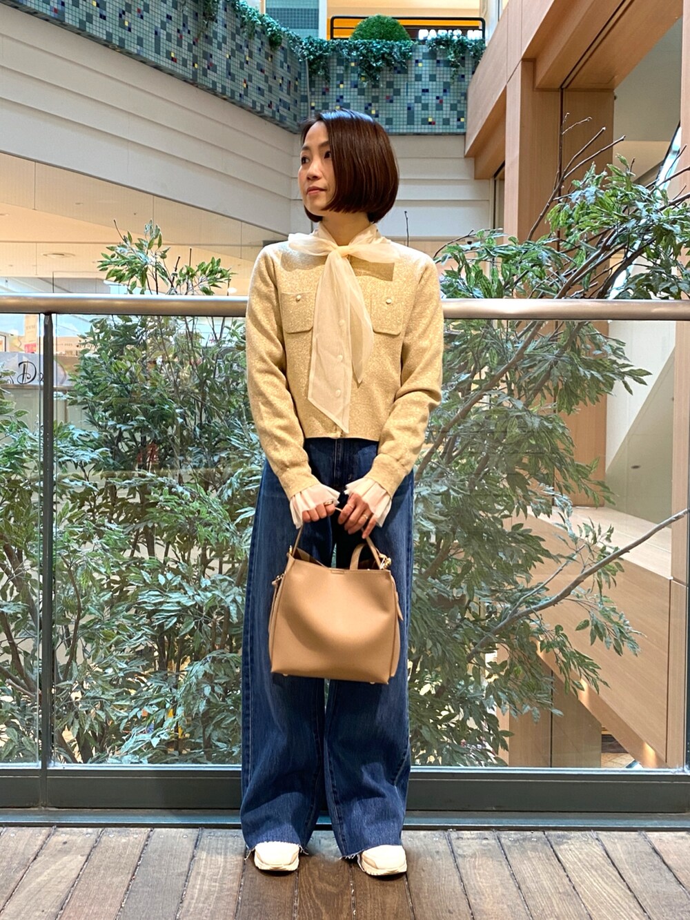 ホワイト系のシャツ/ブラウス、ベージュ系のカーディガン/ボレロ、ブルー系のデニムパンツを着用したレディースの冬コーディネートの2枚目の写真