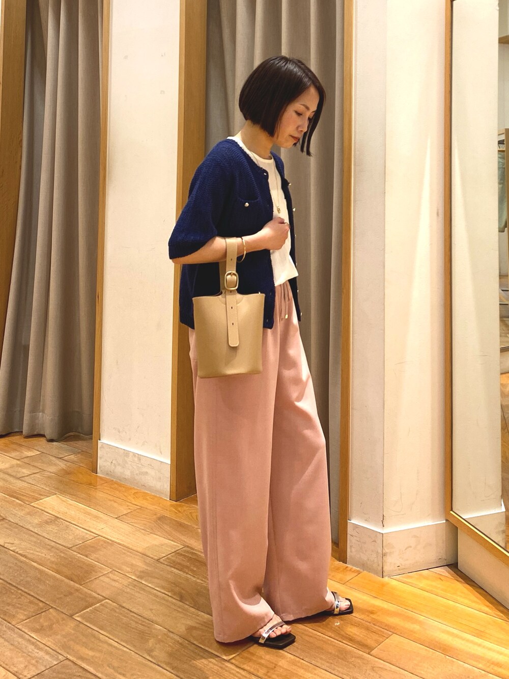 ピンク系のその他パンツ、ベージュ系のショルダーバッグ、ブルー系のカーディガン/ボレロを着用したレディースの春コーディネートの5枚目の写真