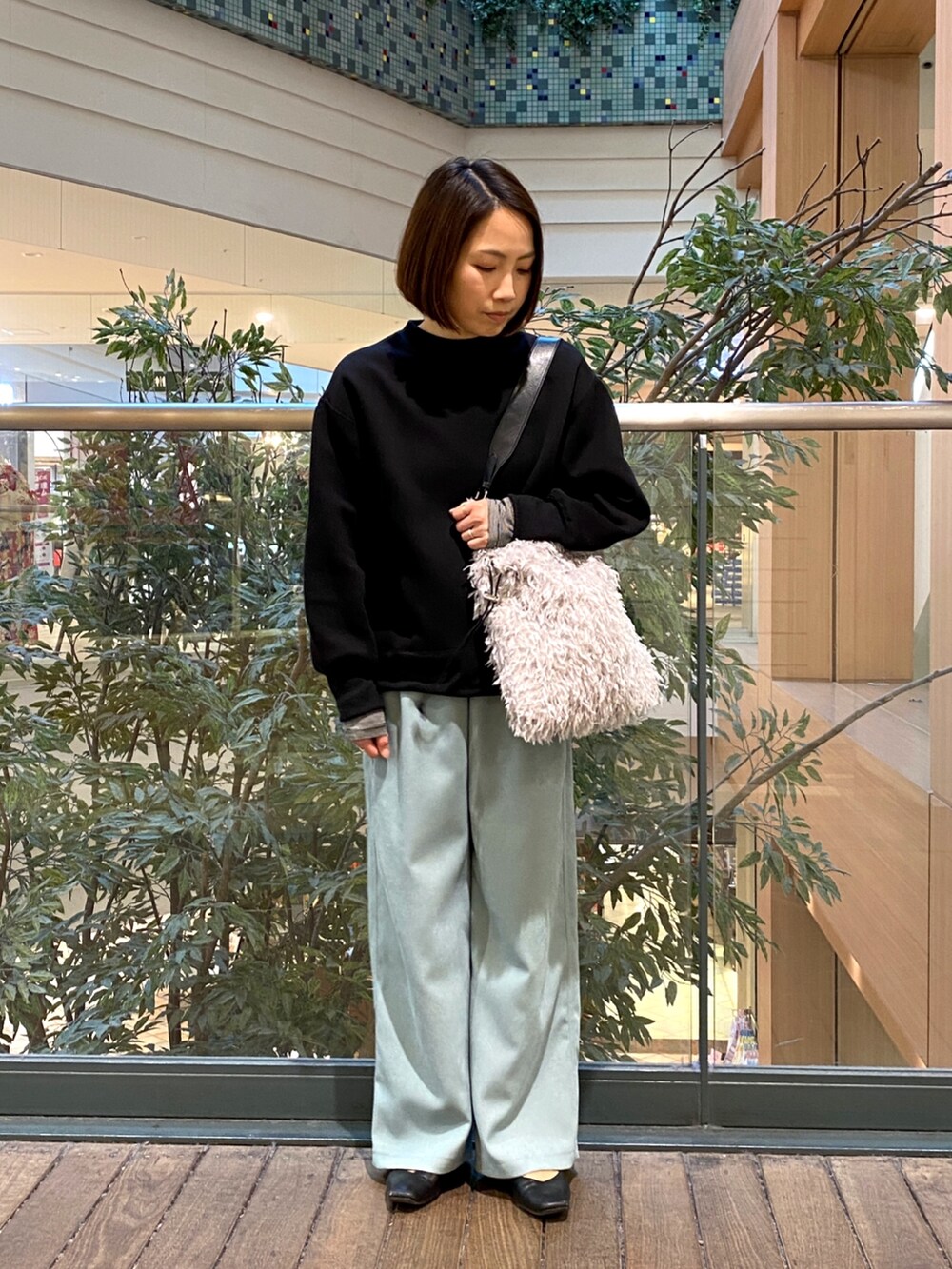 ブルー系のその他パンツ、グレー系のハンドバッグ、ブラック系のTシャツ/カットソーを着用したレディースの冬コーディネートの2枚目の写真