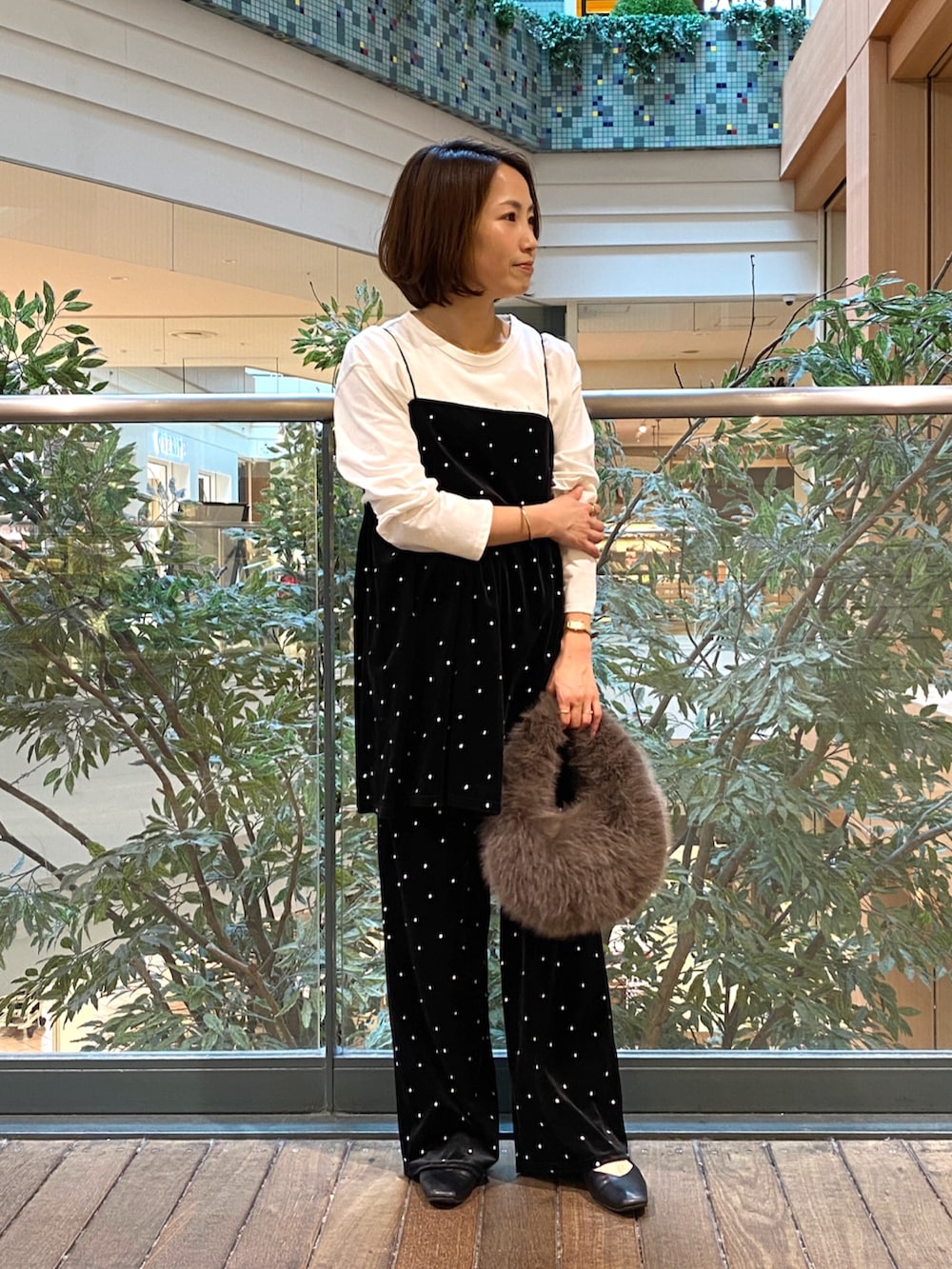 ブラック系のキャミソール、ホワイト系のTシャツ/カットソー、グレー系のハンドバッグを着用したレディースの秋コーディネートの2枚目の写真