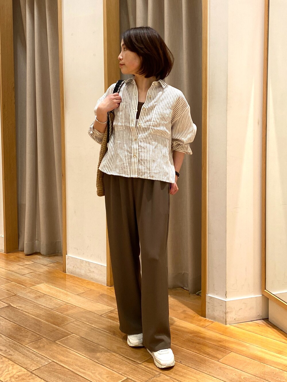 ブラウン系のその他パンツ、ベージュ系のトートバッグ、ベージュ系のシャツ/ブラウスを着用したレディースの春コーディネートの2枚目の写真