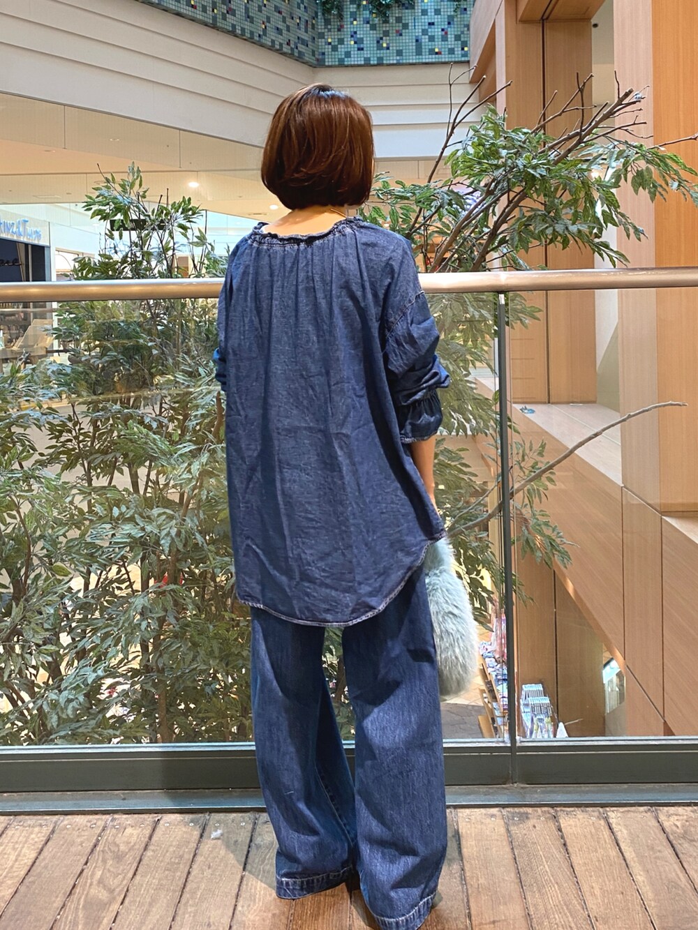 ブルー系のシャツ/ブラウス、ブルー系のデニムパンツ、ホワイト系のTシャツ/カットソーを着用したレディースの秋コーディネートの6枚目の写真