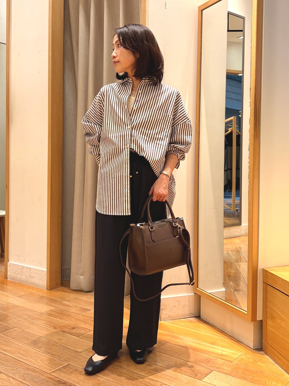 ブラック系のその他パンツ、ブラウン系のシャツ/ブラウス、ブラウン系のボストンバッグを着用したレディースの秋コーディネートの2枚目の写真