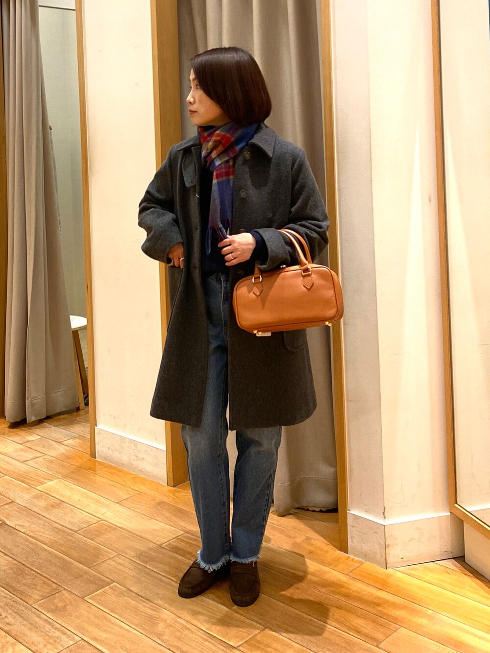 グレー系のダッフルコート、ブルー系のニット/セーター、ブルー系のデニムパンツを着用したレディースの冬コーディネートの3枚目の写真