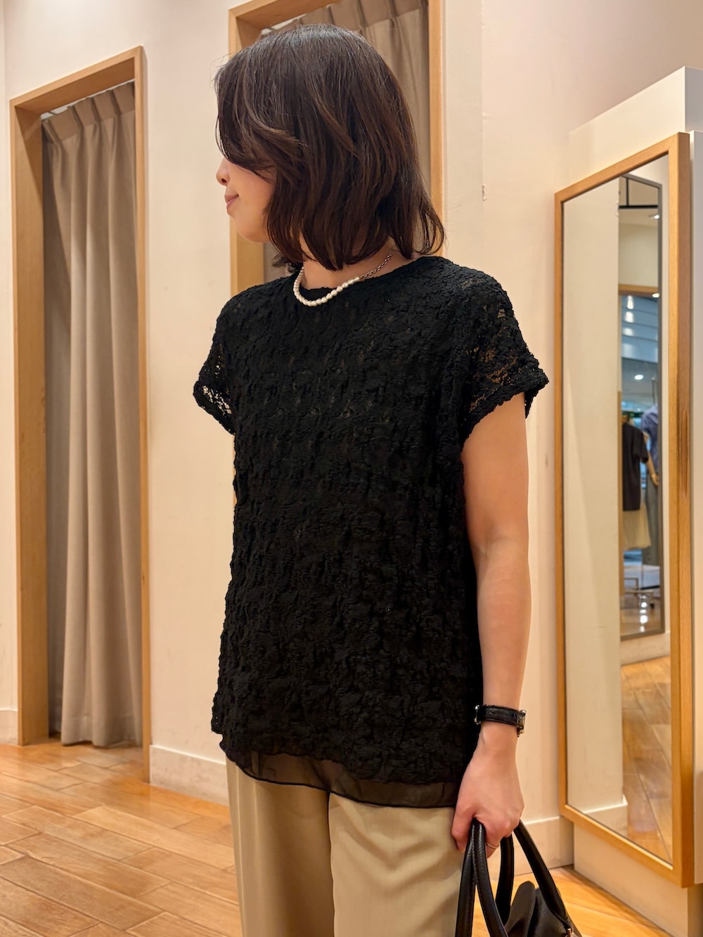 ベージュ系のその他パンツ、ブラック系のボストンバッグ、ブラック系のTシャツ/カットソーを着用したレディースの夏コーディネートの3枚目の写真