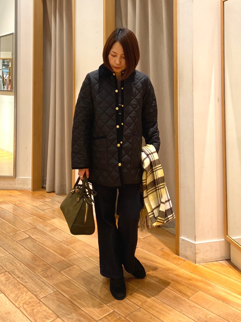 ブルー系のデニムパンツ、ブラック系のブルゾン、グリーン系のショルダーバッグを着用したレディースの秋コーディネートの4枚目の写真