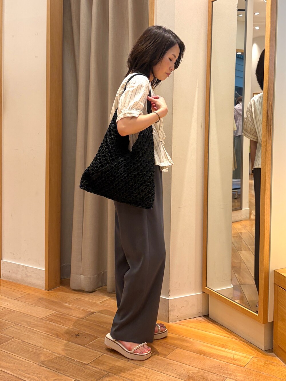 グレー系のその他パンツ、ホワイト系のシャツ/ブラウス、ブラック系のショルダーバッグを着用したレディースの夏コーディネートの5枚目の写真