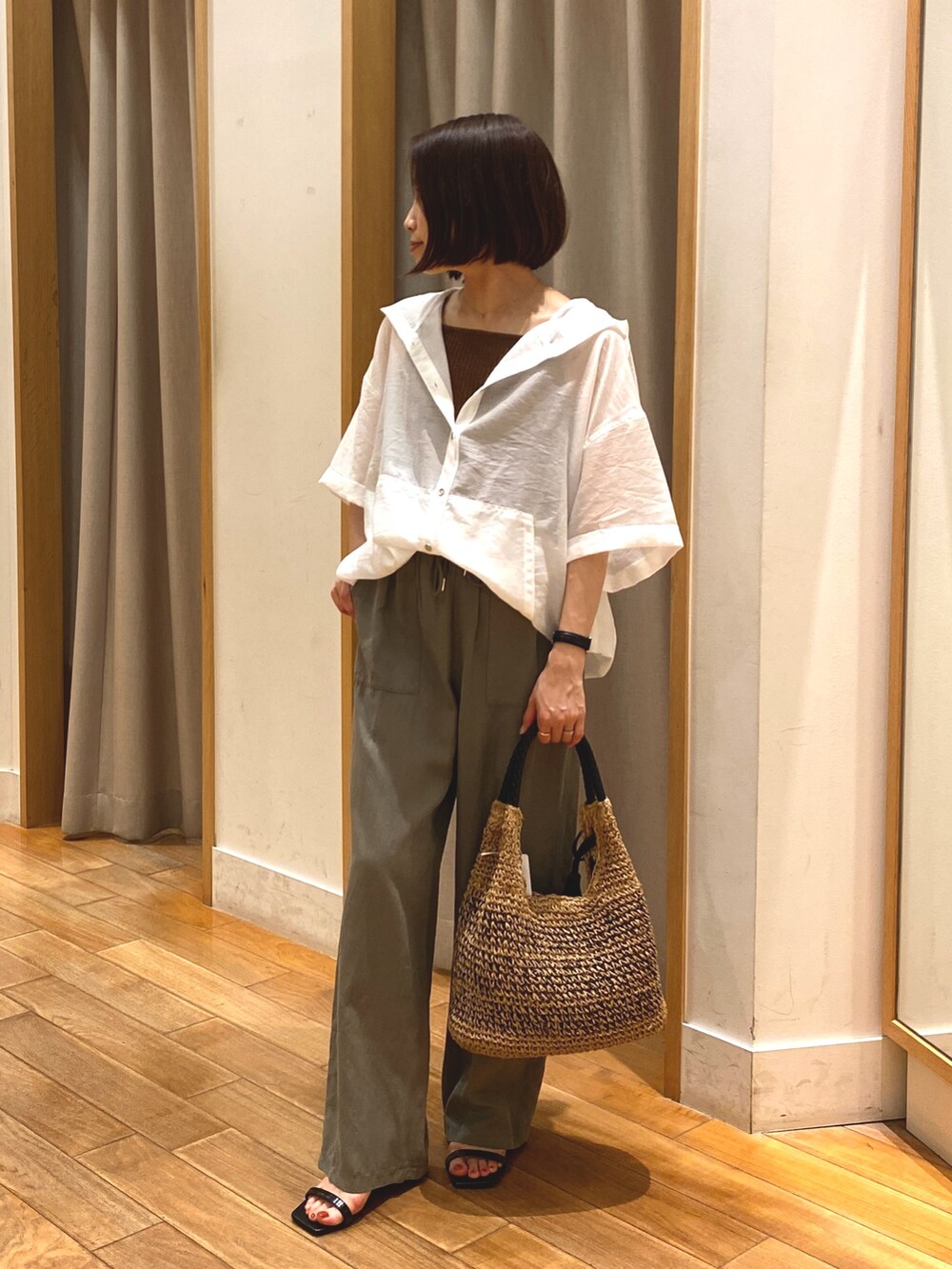 ホワイト系のシャツ/ブラウス、ブラウン系のTシャツ/カットソー、ブラウン系のかごバッグを着用したレディースの夏コーディネートの3枚目の写真