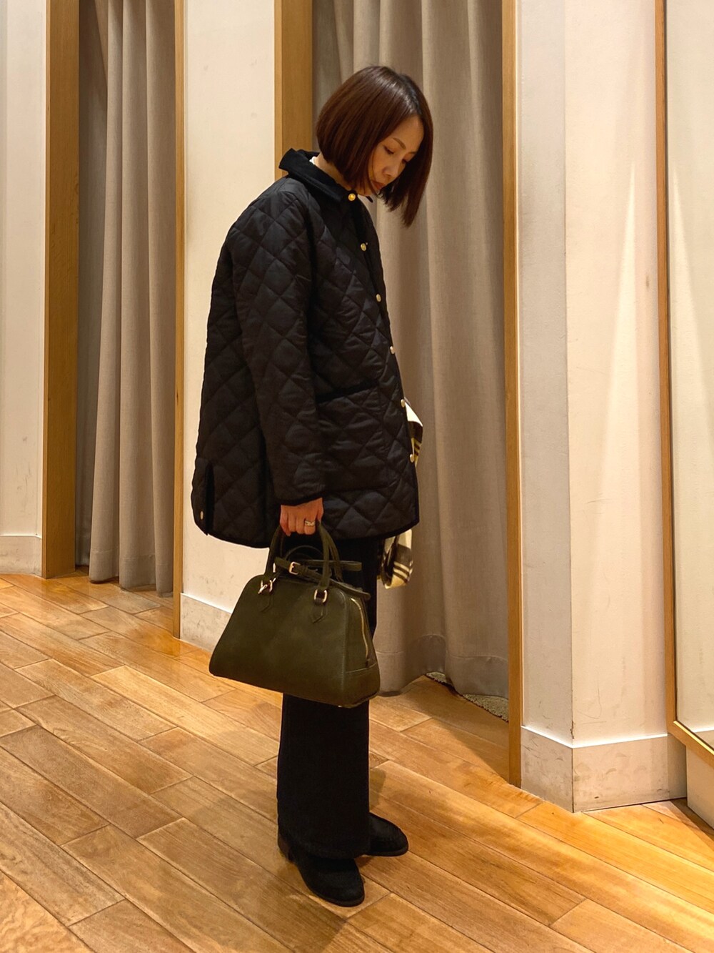 ブルー系のデニムパンツ、ブラック系のブルゾン、グリーン系のショルダーバッグを着用したレディースの秋コーディネートの6枚目の写真