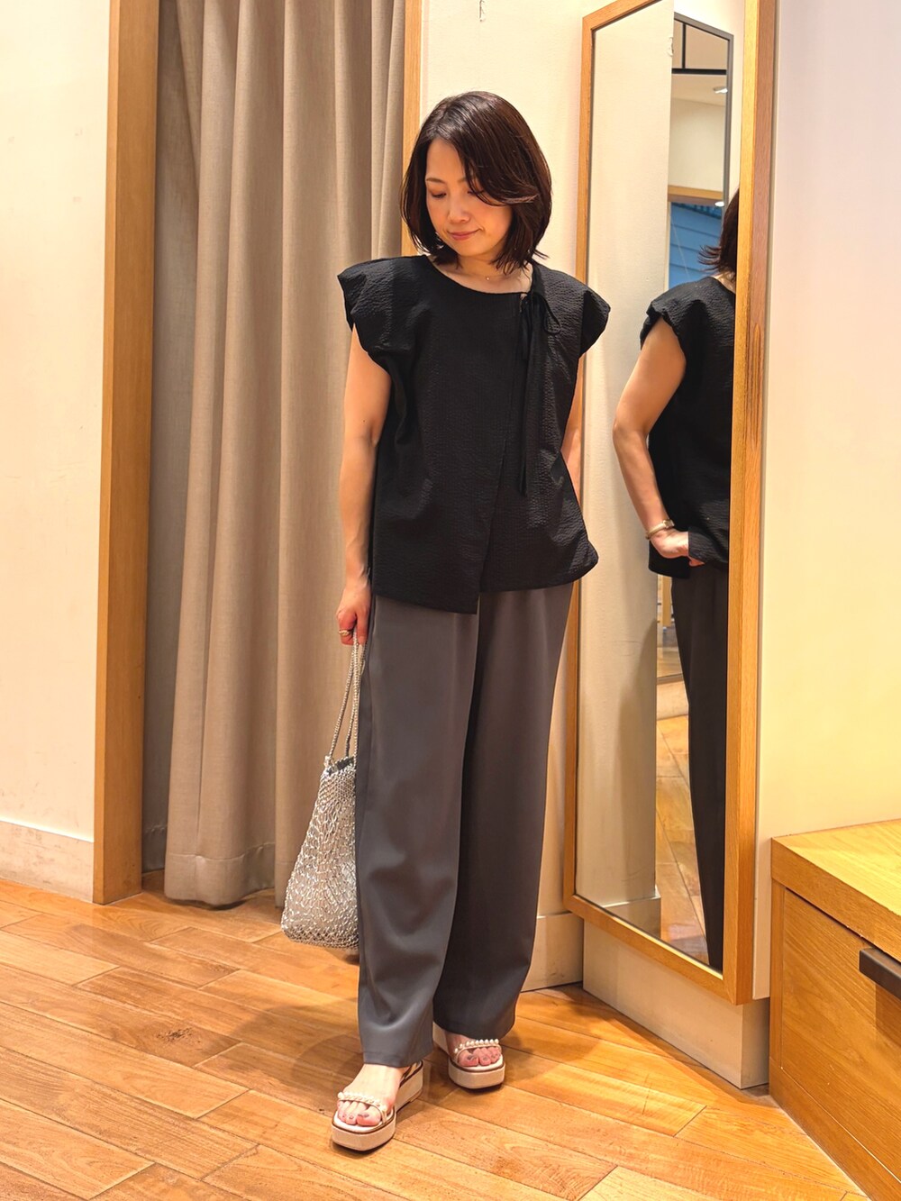 ブラック系のシャツ/ブラウス、グレー系のその他パンツ、シルバー系のかごバッグを着用したレディースの夏コーディネートの2枚目の写真