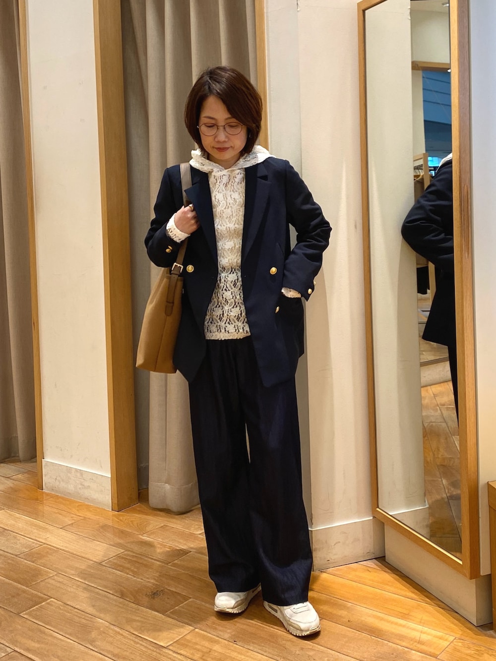 ブラウン系のショルダーバッグ、ホワイト系のTシャツ/カットソー、ブルー系のテーラードジャケットを着用したレディースの春コーディネートの2枚目の写真