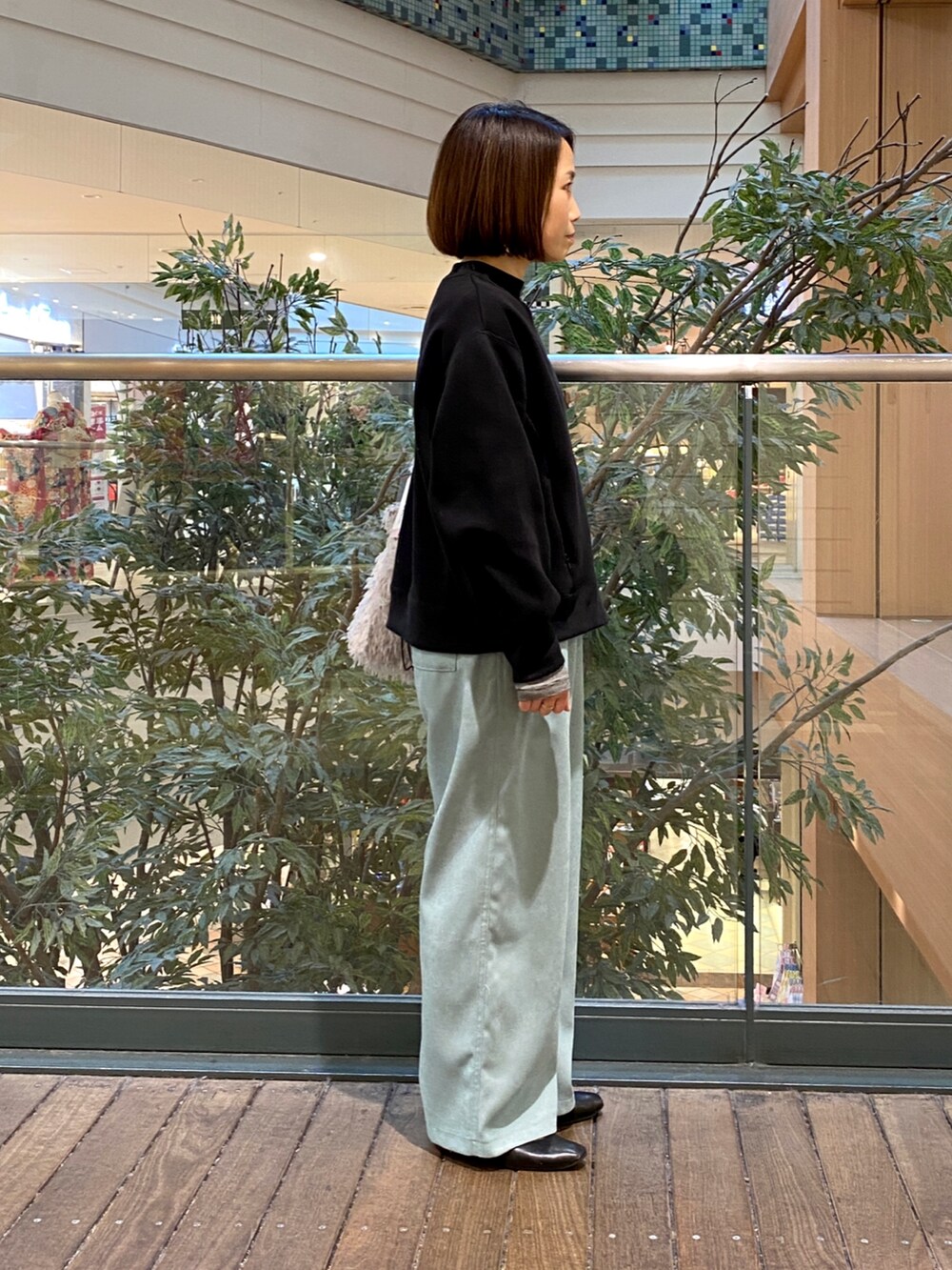 ブルー系のその他パンツ、グレー系のハンドバッグ、ブラック系のTシャツ/カットソーを着用したレディースの冬コーディネートの4枚目の写真