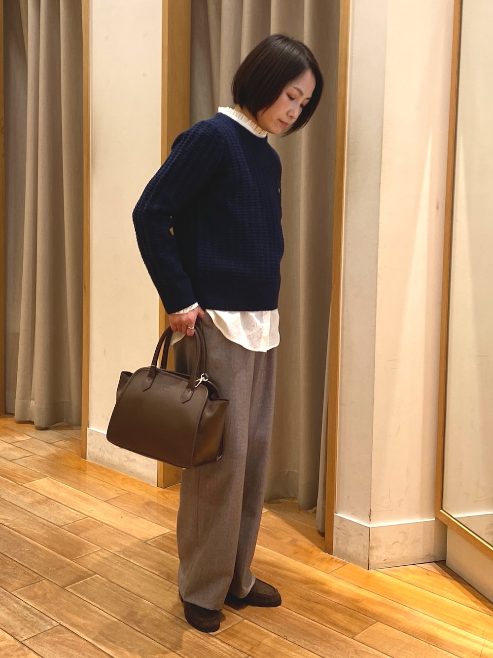 ベージュ系のその他パンツ、ホワイト系のシャツ/ブラウス、ブルー系のニット/セーターを着用したレディースの冬コーディネートの3枚目の写真