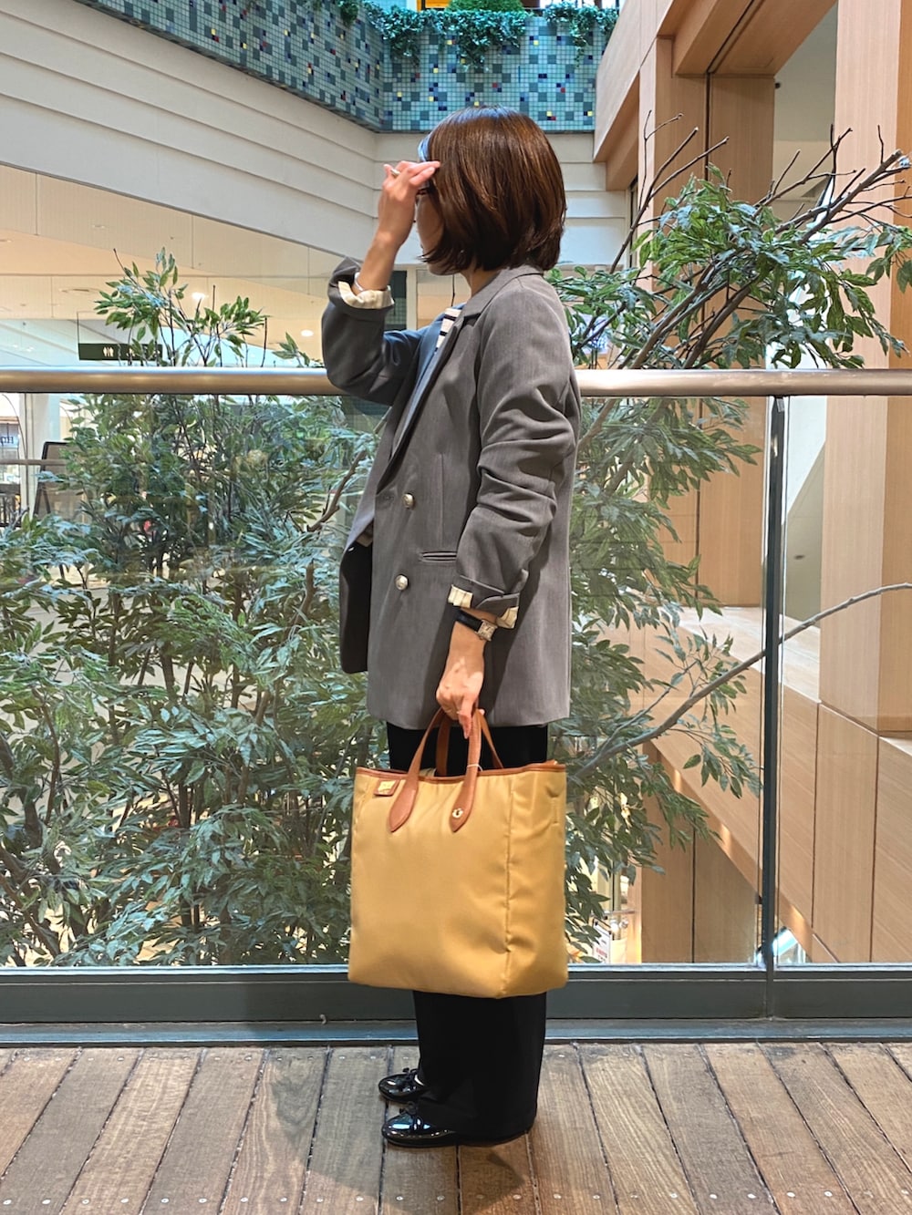 グレー系のテーラードジャケット、ホワイト系のTシャツ/カットソー、ブラック系のチノパンツを着用したレディースの秋コーディネートの3枚目の写真