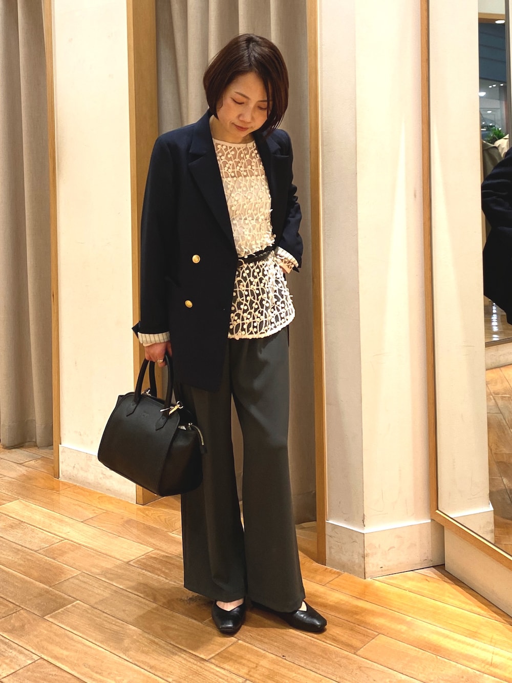 グレー系のその他パンツ、ブラック系のショルダーバッグ、ホワイト系のシャツ/ブラウスを着用したレディースの春コーディネートの4枚目の写真