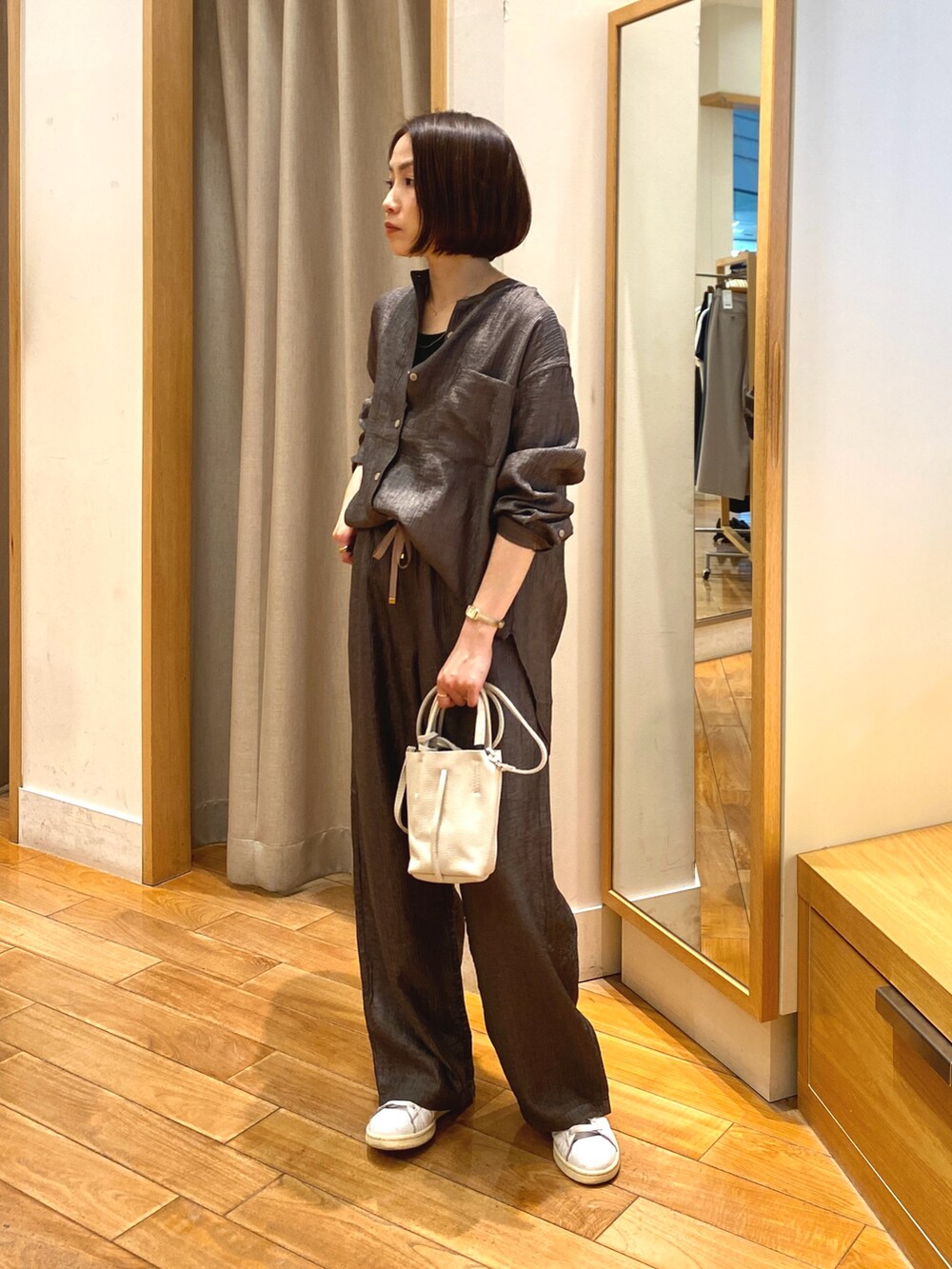 ブラウン系のシャツ/ブラウス、ブラウン系のその他パンツ、ホワイト系のショルダーバッグを着用したレディースの春コーディネートの2枚目の写真