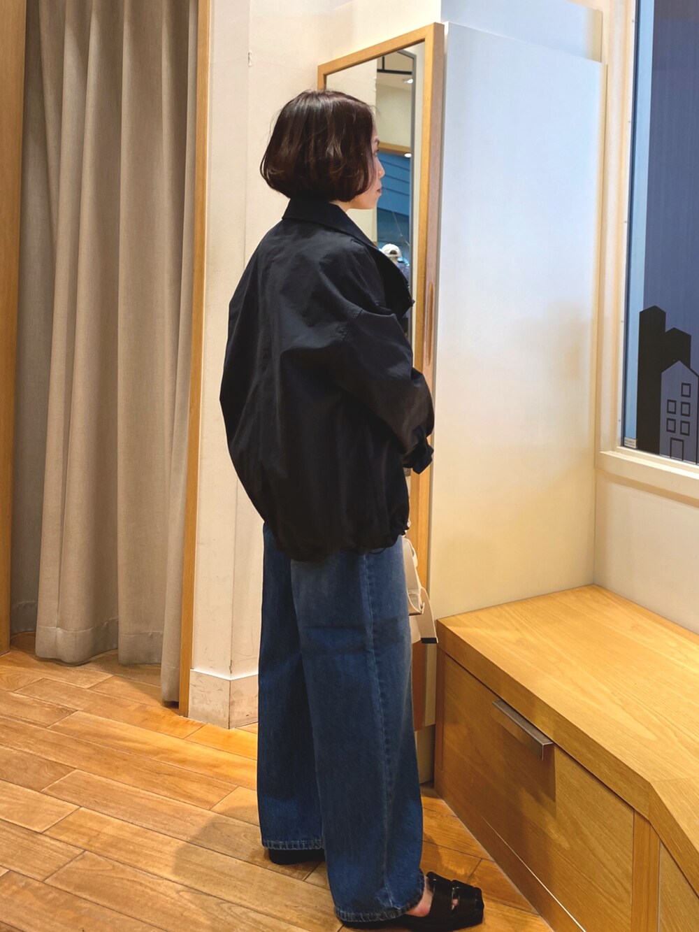 ブルー系のデニムパンツ、ブルー系のTシャツ/カットソー、ホワイト系のショルダーバッグを着用したレディースの春コーディネートの4枚目の写真