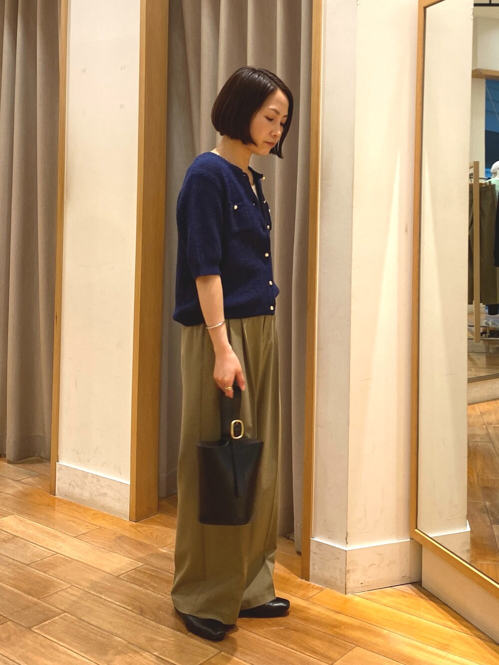 ブルー系のカーディガン/ボレロ、ホワイト系のTシャツ/カットソー、イエロー系のスラックスを着用したレディースの春コーディネートの6枚目の写真
