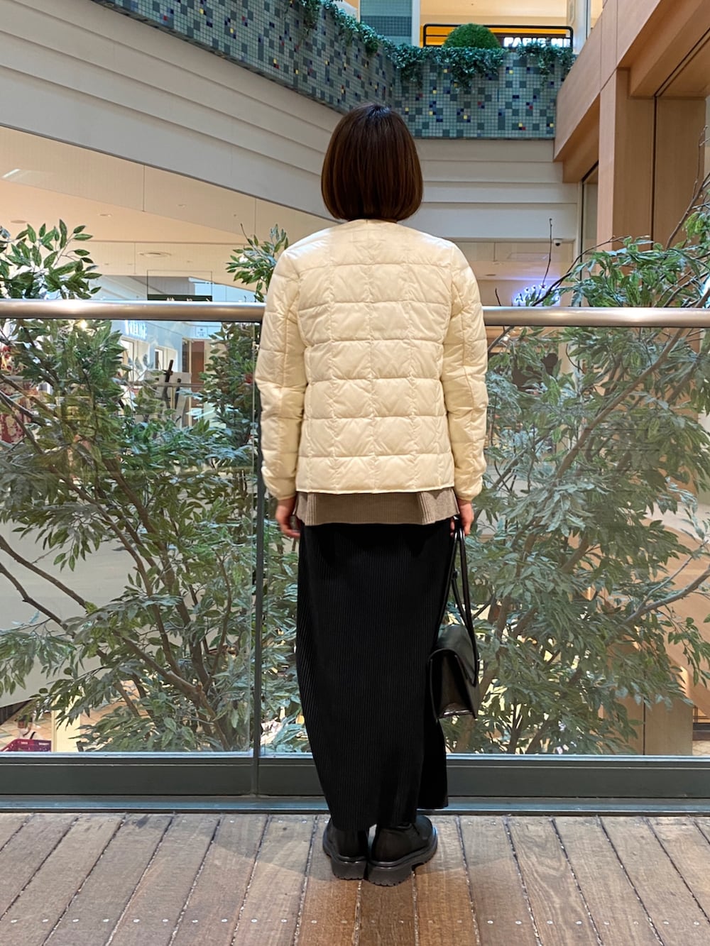 ホワイト系のダウンジャケット/コート、ベージュ系のニット/セーター、ブラック系のTシャツ/カットソーを着用したレディースの冬コーディネートの4枚目の写真