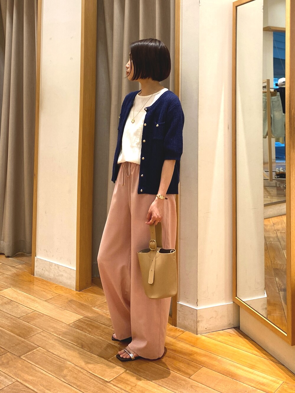 ピンク系のその他パンツ、ベージュ系のショルダーバッグ、ブルー系のカーディガン/ボレロを着用したレディースの春コーディネートの3枚目の写真