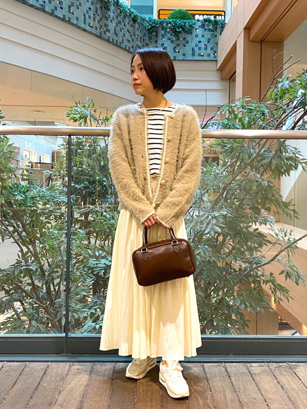 ベージュ系のカーディガン/ボレロ、ホワイト系のTシャツ/カットソー、ホワイト系のスカートを着用したレディースの秋コーディネートの2枚目の写真