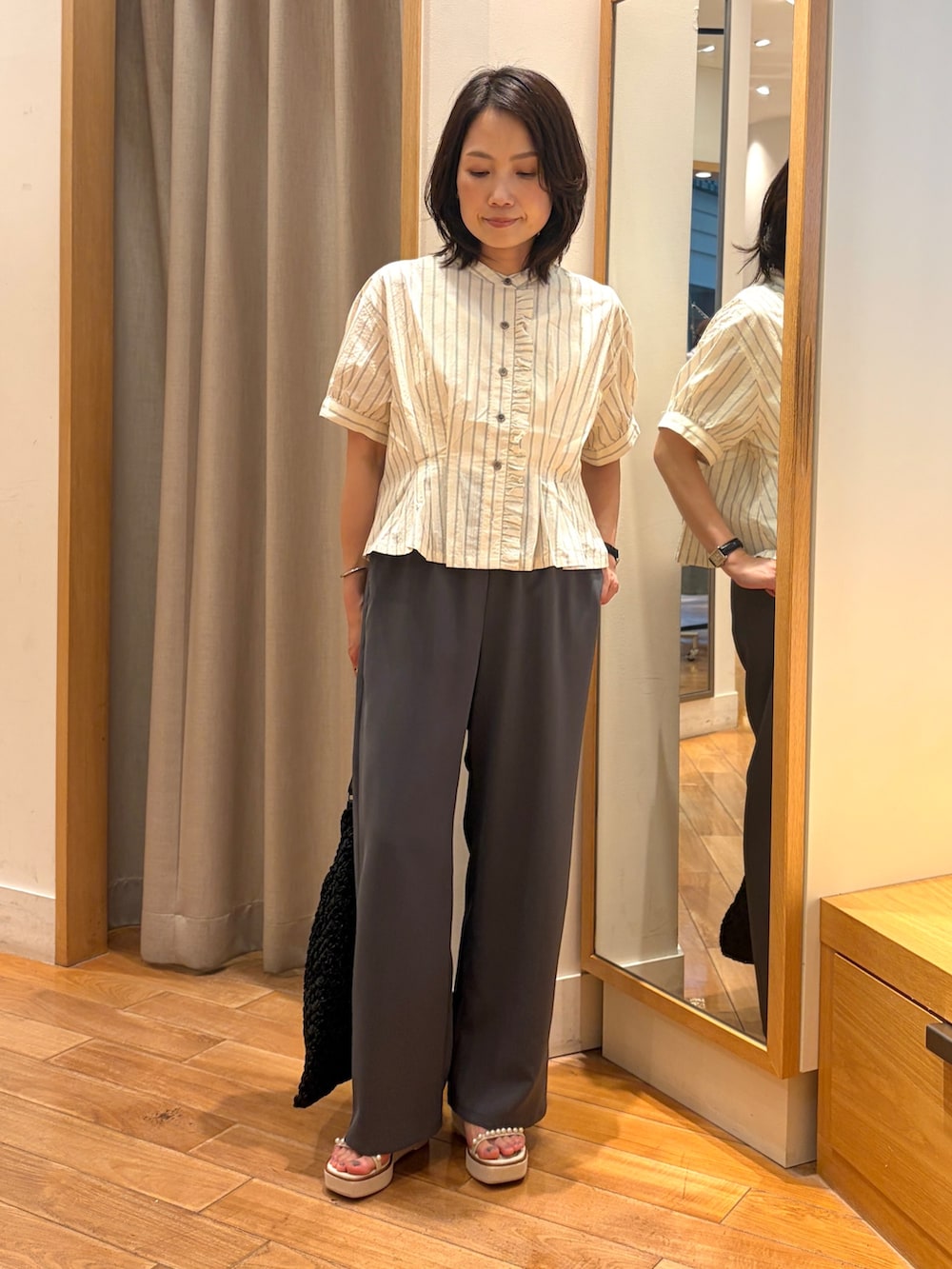 グレー系のその他パンツ、ホワイト系のシャツ/ブラウス、ブラック系のショルダーバッグを着用したレディースの夏コーディネートの4枚目の写真