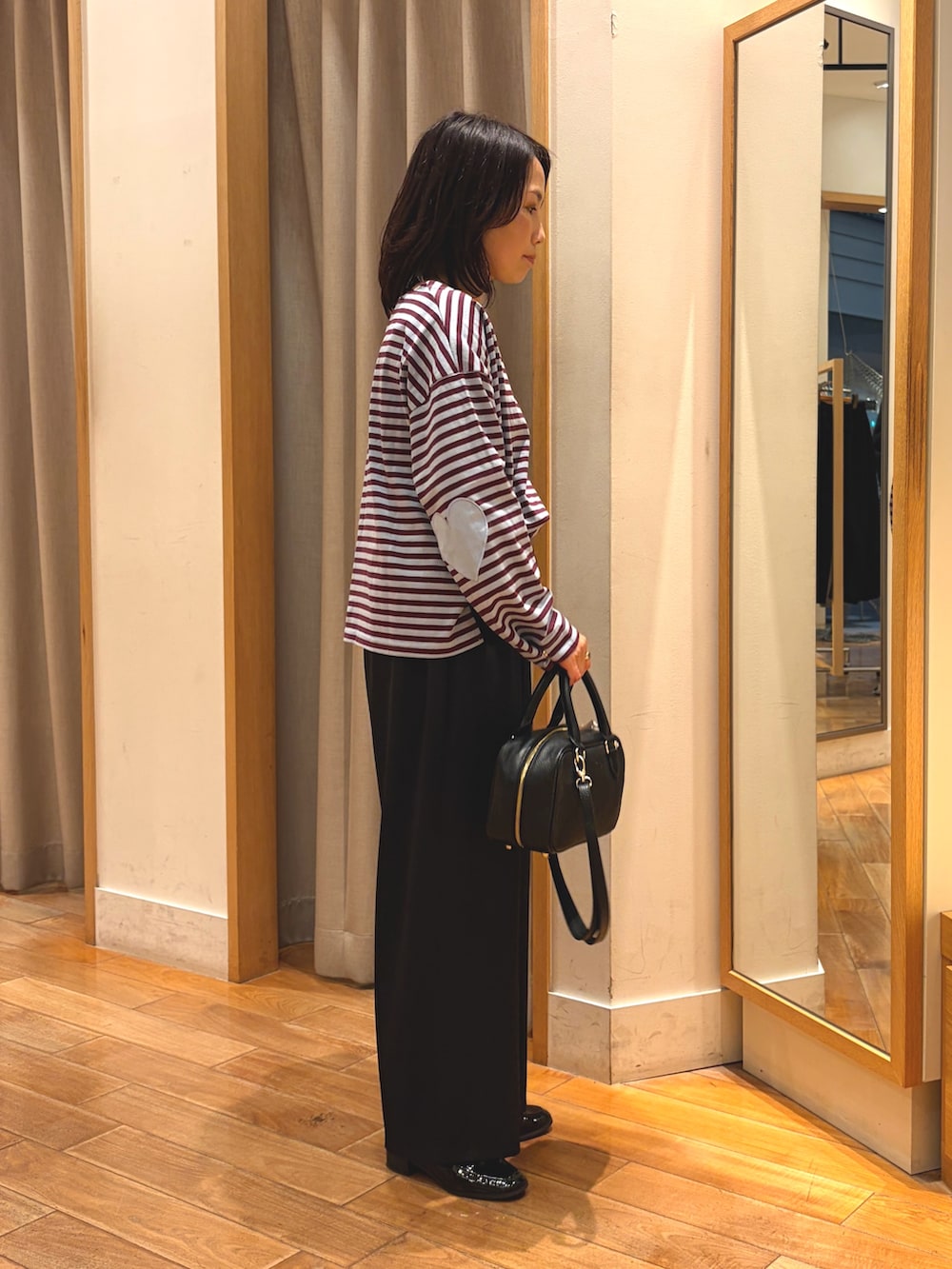 ブラック系のその他パンツ、ブルー系のTシャツ/カットソー、ブラック系のボストンバッグを着用したレディースの秋コーディネートの6枚目の写真