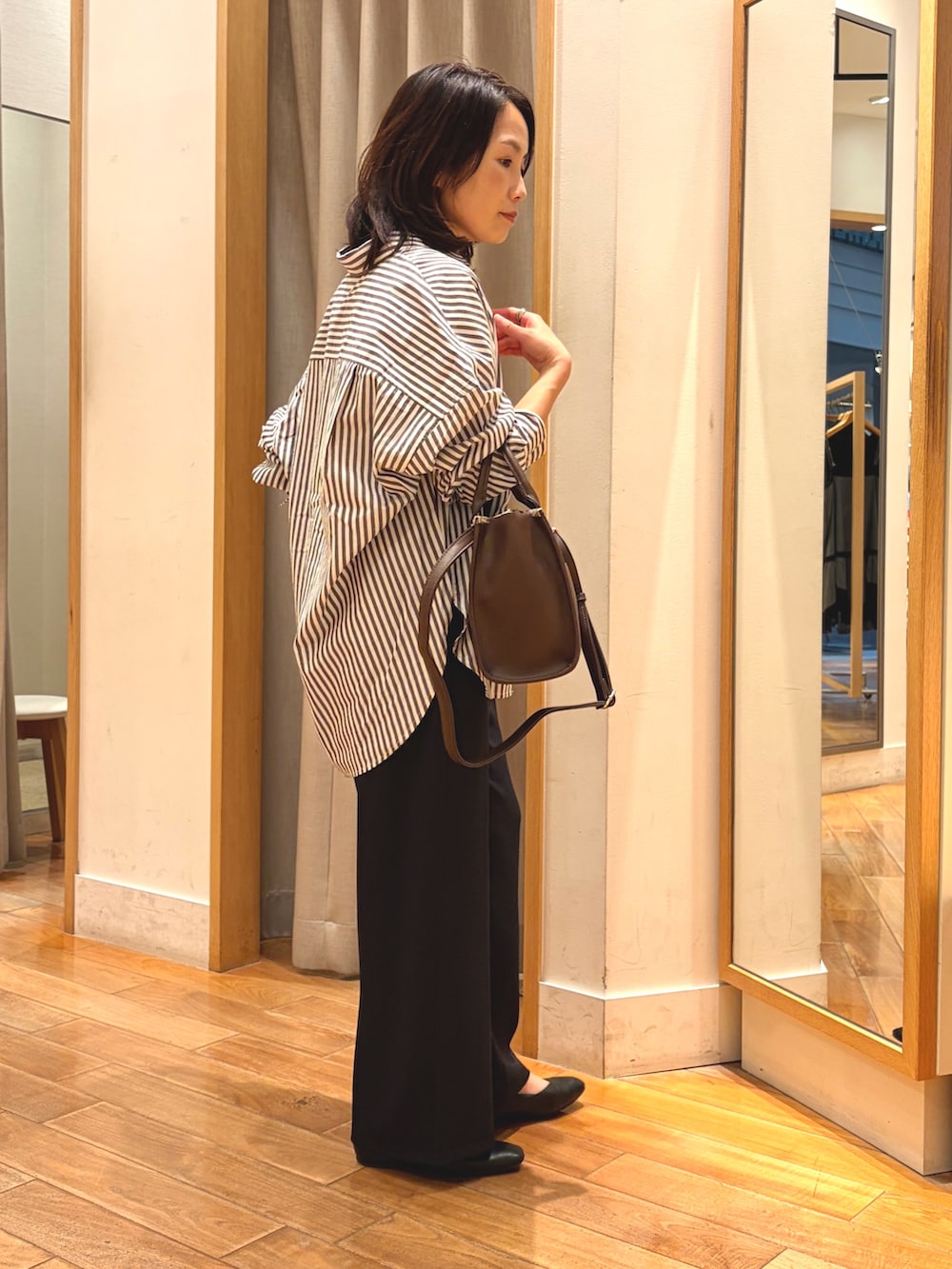 ブラック系のその他パンツ、ブラウン系のシャツ/ブラウス、ブラウン系のボストンバッグを着用したレディースの秋コーディネートの5枚目の写真