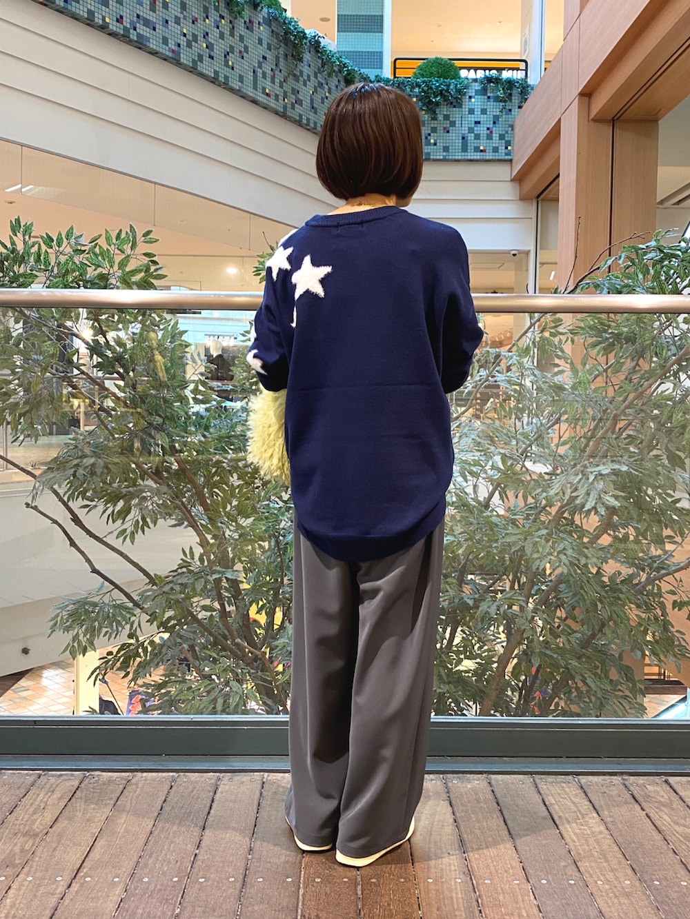 ブルー系のニット/セーター、グレー系のその他パンツ、イエロー系のショルダーバッグを着用したレディースの秋コーディネートの4枚目の写真