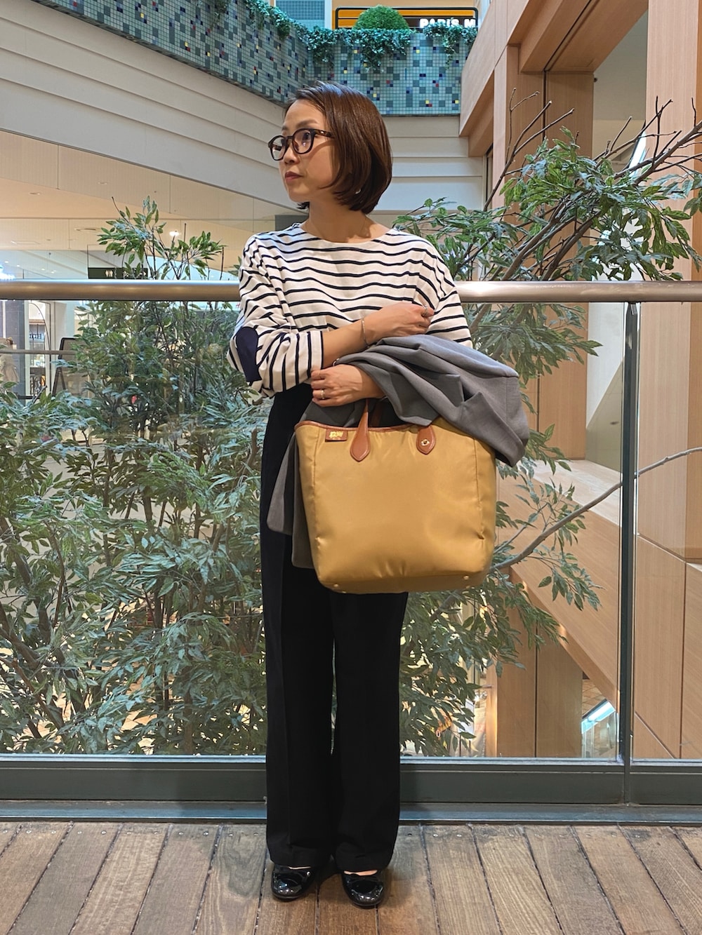 グレー系のテーラードジャケット、ホワイト系のTシャツ/カットソー、ブラック系のチノパンツを着用したレディースの秋コーディネートの6枚目の写真