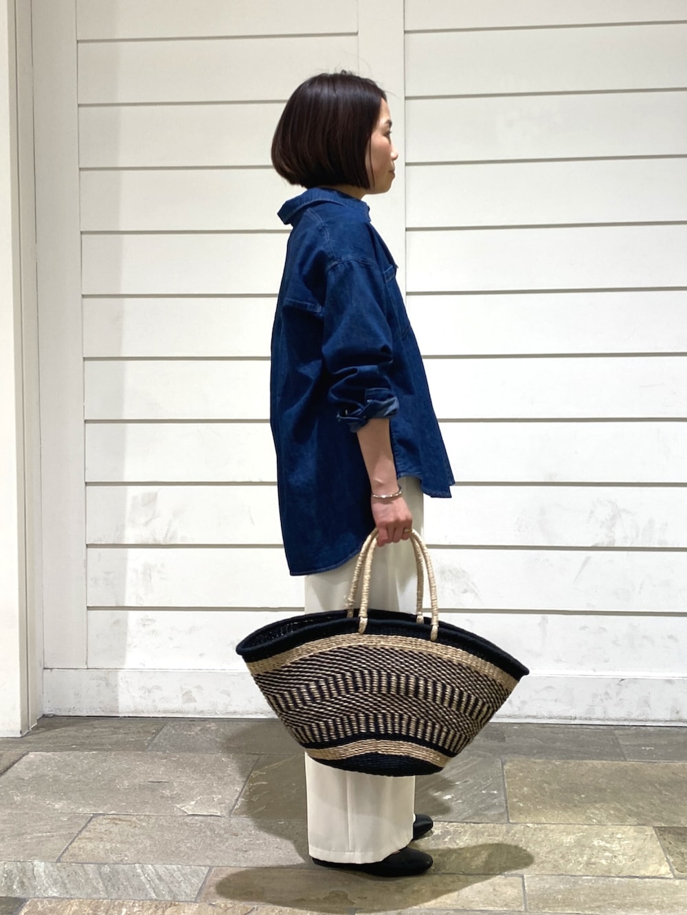 ブルー系のシャツ/ブラウス、ブラック系のかごバッグ、ホワイト系のその他パンツを着用したレディースの春コーディネートの5枚目の写真