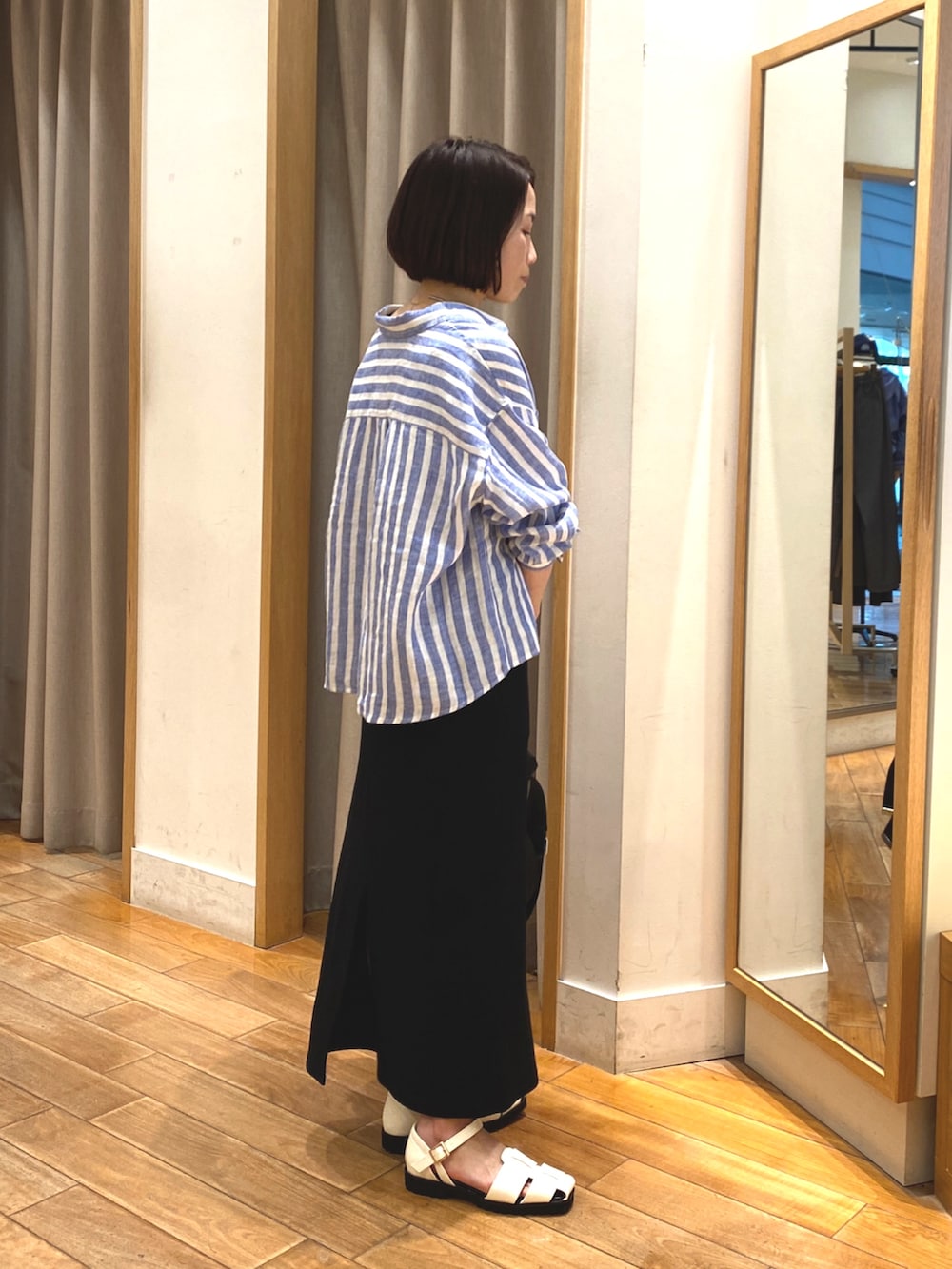 ホワイト系のタンクトップ、ブルー系のシャツ/ブラウス、ブラック系のスカートを着用したレディースの春コーディネートの4枚目の写真